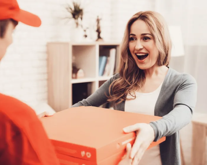 Cliente recebendo encomenda do entregador